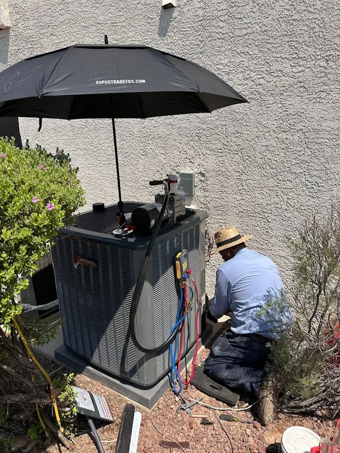 HVAC technician performing outdoor AC maintenance in Arcadia