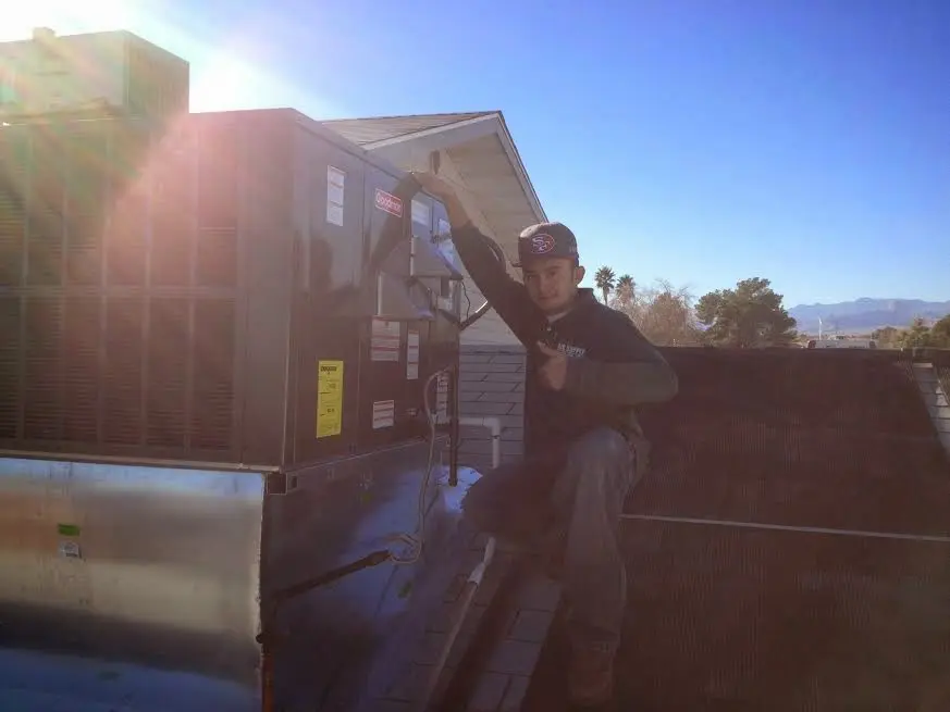 HVAC technician performing AC Tune-Up on a rooftop unit in Arcadia